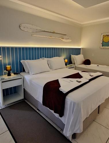a hotel room with a large bed with white sheets at Navega Hotéis in Navegantes