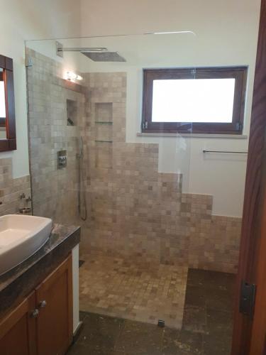 a bathroom with a shower and a sink at Casinha Laranja in Monchique
