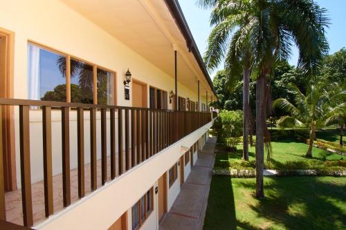 a balcony of a house with palm trees at La Iguana de Santa Fe by Bernalo Hotels in Santa Fe de Antioquia