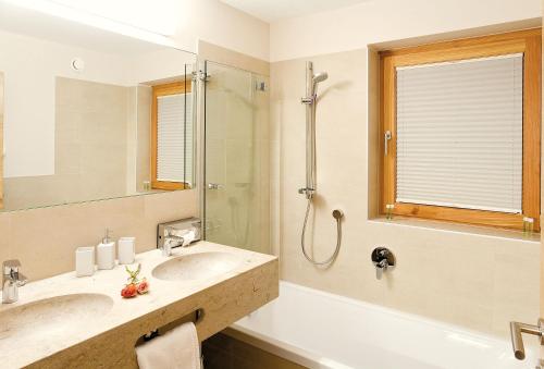 a bathroom with two sinks and a shower at Das Tannberg in Lech am Arlberg