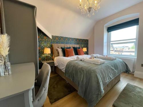a bedroom with a bed and a desk and a chandelier at Jorvik Villa in York