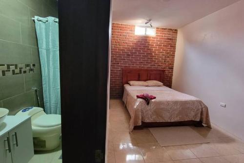 a bedroom with a bed and a brick wall at Agradable casa familiar cerca de Los Frailes in Puerto López