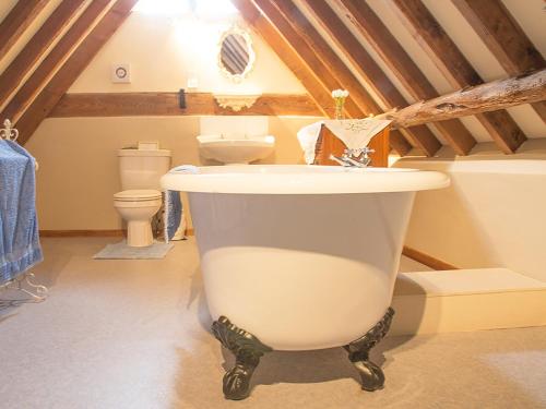 a bathroom with a large white tub in a attic at Old Corn Mill - Ukc3170 in Walpole