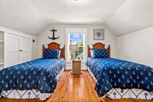 two beds in a room with wooden floors at Beautiful Cottage In Downtown Bristol in Bristol