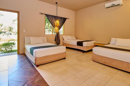 a bedroom with two beds and a window at La Iguana de Santa Fe by Bernalo Hotels in Santa Fe de Antioquia