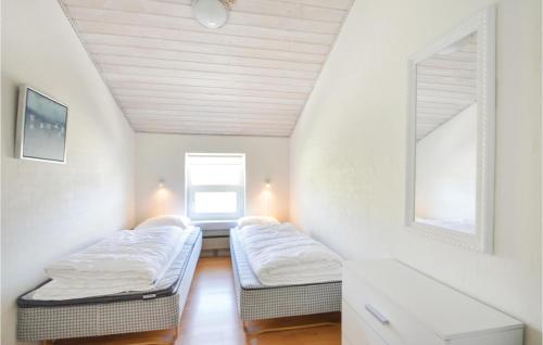 a attic room with two beds and a window at Amazing Home In Vestervig With 4 Bedrooms, Sauna And Indoor Swimming Pool in Vestervig