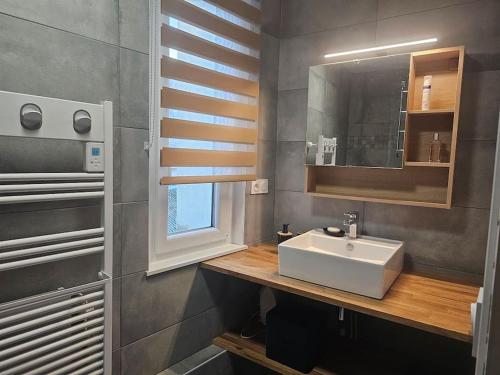 une salle de bain avec un lavabo blanc et un miroir dans l'établissement L'Estran, à Dieppe