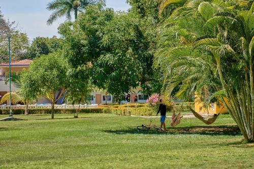 a person standing under a palm tree in a park at La Iguana de Santa Fe by Bernalo Hotels in Santa Fe de Antioquia