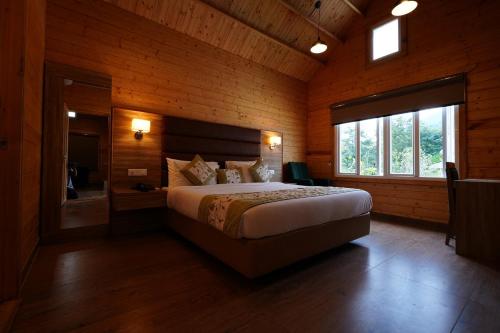 1 dormitorio con 1 cama grande en una habitación de madera en Antaraal Resort & Spa A Village Resort en Dharamshala