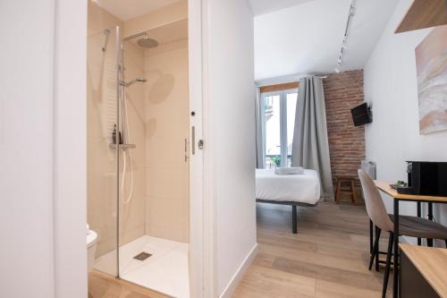 een badkamer met een douche en een glazen deur bij Old Town Homestay in San Sebastian