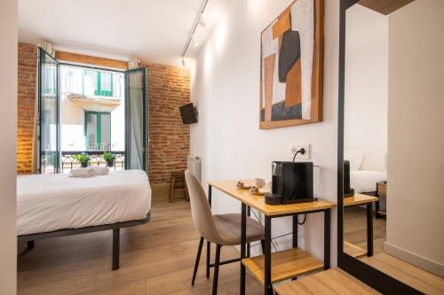 a bedroom with a bed and a desk with a television at Old Town Homestay in San Sebastián