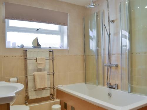 ein Bad mit einer Badewanne, einem Waschbecken und einer Dusche in der Unterkunft Coastal Dream in Burton