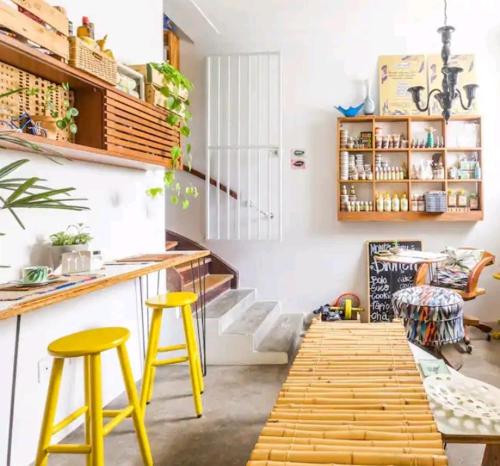 a kitchen with two yellow stools and a counter at Beach Apartment in Tel Aviv
