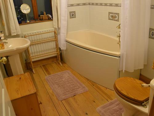 a bathroom with a tub and a toilet and a sink at Willow Down in Downham