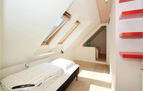 a bedroom with a bed in a loft with a window at 5 Bedroom Stunning Home In Stakroge in Knaplund