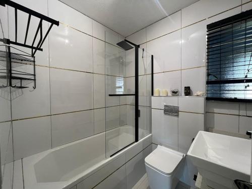 a bathroom with a tub and a toilet and a sink at Royal Retreat in Roodepoort