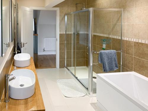 a bathroom with a shower and a toilet and a sink at Harrowbeard House in Marhamchurch