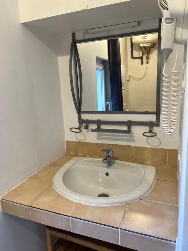 La salle de bains est pourvue d'un lavabo et d'un miroir sur un comptoir. dans l'établissement Studio cosy Hyper Centre Grenoble, à Grenoble