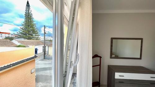 a room with a window with a view of a tree at Surfers Den - One Bedroom Flat - Baleal in Ferrel