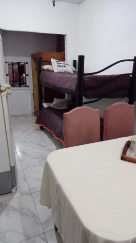 Cette chambre comprend un lit, des chaises et un piano. dans l'établissement Casa Canela, à Ezeiza