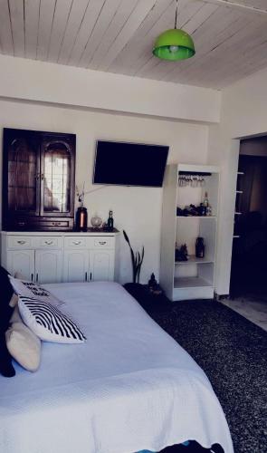 a bedroom with a white bed and a green light at Casa Canela in Ezeiza