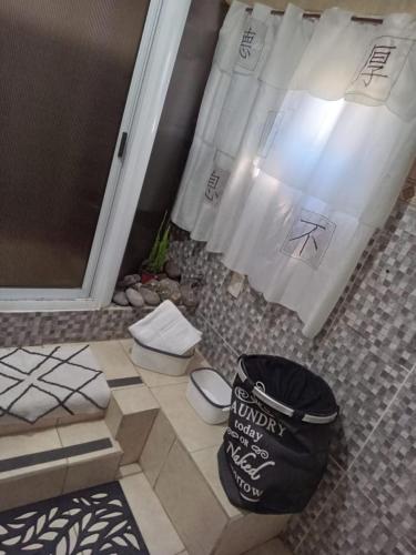 a bathroom with a toilet and a bag on the floor at Casa Canela in Ezeiza
