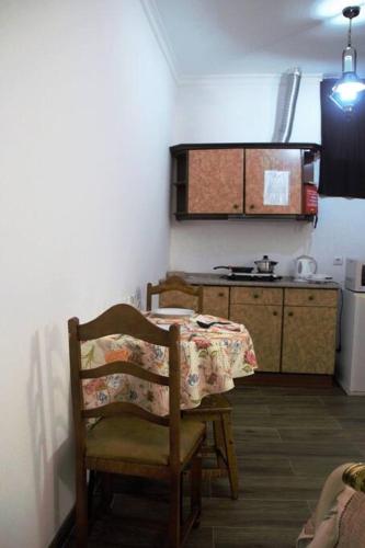 a kitchen with a table and a kitchen with a refrigerator at Casa das Matriarcas - Casa da Avó Judite in Belmonte