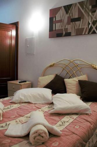 a woman laying on top of a bed with pillows at Casa das Matriarcas - Casa da Avó Judite in Belmonte