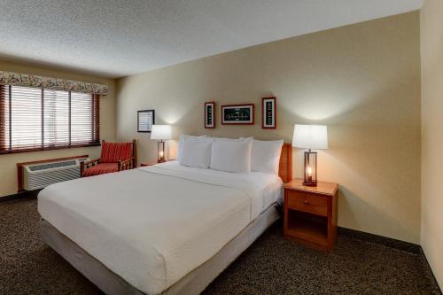 a bedroom with a large white bed and a chair at Stoney Creek lnn Galena in Galena