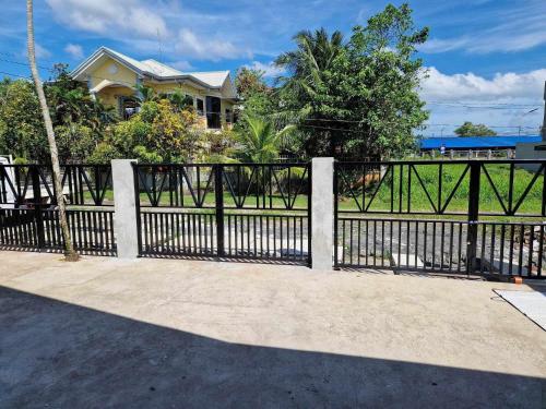 uma cerca preta em frente a uma casa em Waray WaRaE Haven em Tacloban