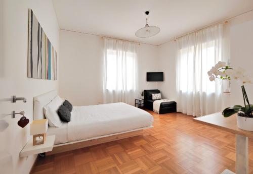 ヴェローナにあるCorte Melone room rentalの白いベッドルーム(ベッド1台、椅子付)