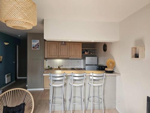 une cuisine avec un bar avec trois tabourets dans l'établissement L'échappée belle, à Dieppe