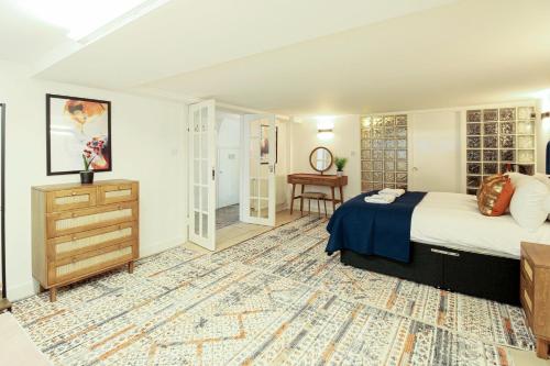 a bedroom with a bed and a dresser in a room at London South Kensington mews house near Natural History Museum and tube in London