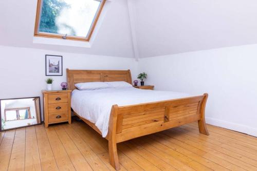 a bedroom with a wooden bed and a mirror at Detached house with gated parking in Whalley Range in Manchester