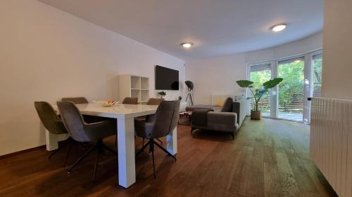 a living room with a dining room table and chairs at Forrest-Hugging Townhouse with Private Garden in Zagreb