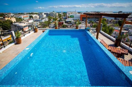 - une grande piscine bleue au-dessus d'un bâtiment dans l'établissement Fancy Loft near 5th av and beach, à Playa del Carmen