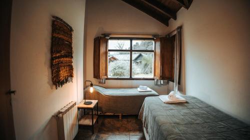Habitación pequeña con cama y ventana en Sombra Verde en Villa La Angostura