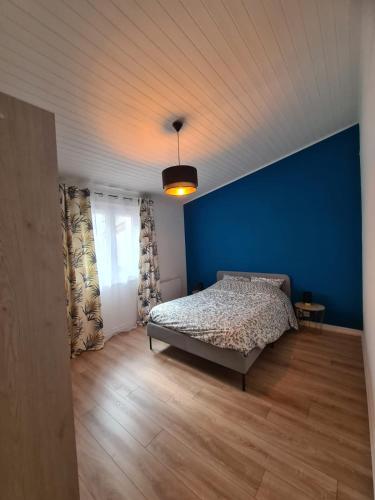 a bedroom with a bed and a blue wall at Charmant appartement au cœur de Saint-peray in Saint-Péray