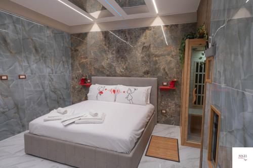- une chambre avec un lit et un mur en pierre dans l'établissement MAGIA LUXURY ROOM & SPA, à Trecase