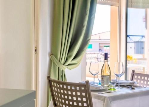 a table with a green curtain and wine glasses at Residence with swimming-pool in Marina di Cecina just 700 meters from the beach in Cecina
