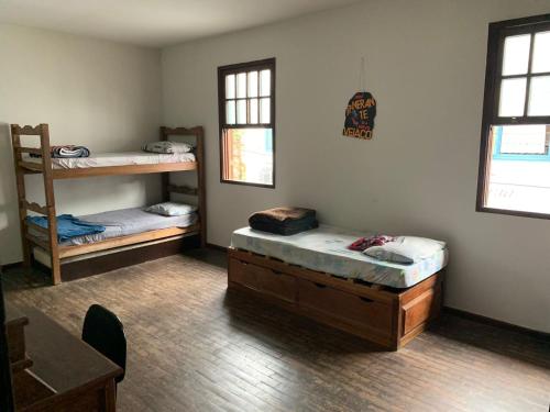 a room with two bunk beds and a table at Republica Do Arco Da Velha in Ouro Preto