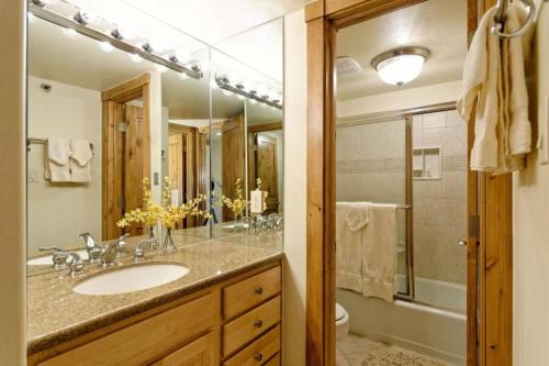 y baño con lavabo, aseo y espejo. en Snowmass Slopeside Condominiums, en Aspen