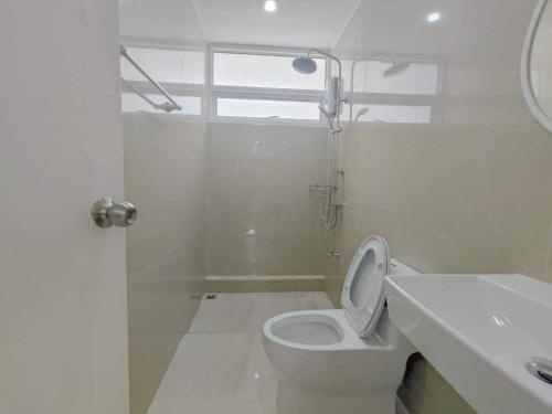 a white bathroom with a toilet and a sink at Sealife4 Beach Pool Villa in Rayong