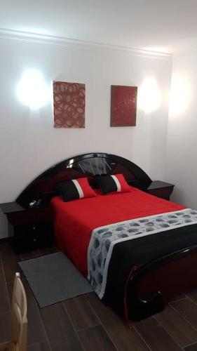 um quarto com uma cama com um cobertor vermelho em Casa das Matriarcas- Casa da Avó Raquel em Belmonte