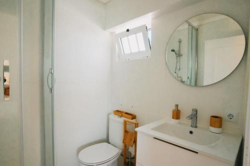 un bagno con un water, un lavandino e uno specchio di Villa Rafa a Costa Nova
