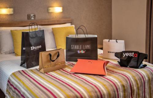 a bed with shopping bags on top of it at The Lodge Hotel in Coleraine