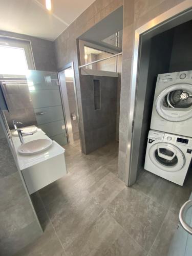a bathroom with a washing machine and a washer at Charmant appartement près de EPFL UNIL Lausanne in Renens