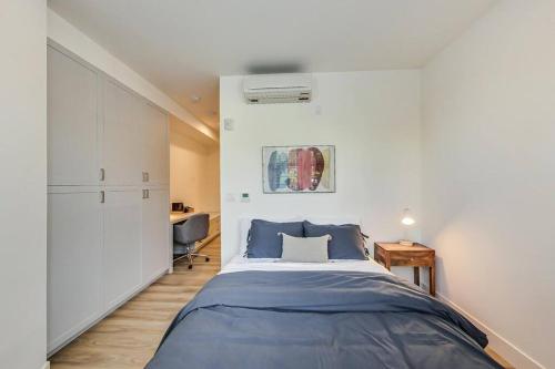 a bedroom with a blue bed and a desk at Luxury Studio Apt in Lake Merritt in Oakland