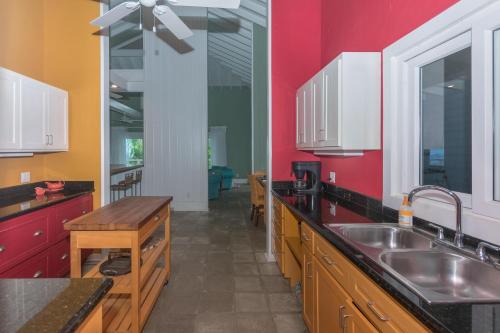 cocina con fregadero y pared roja en Casa Afortunada - 2 bedrooms, en Sandy Bay