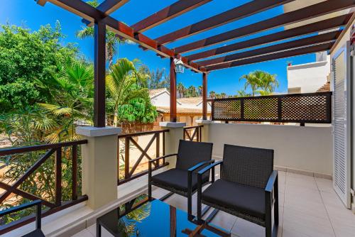 balcón con 2 sillas y vistas al océano en Oasis Golf house in Las Americas en Arona